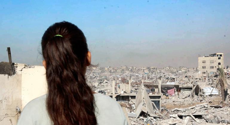 الطفلة الفلسطينية سيلين تقف على سطح منزلها المدمر في غزة، وتنظر إلى الدمار الذي عمّ المدينة.